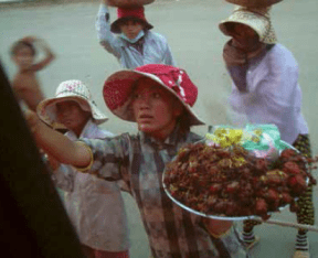 A food vendor approaches Lang's tour bus during a border stop between Vietnam and Cambodia