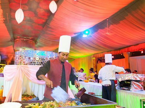 Courtesy of Ravi Sinha/Lucky Malhotra Photography.  Ravi Sinha preparing grilled vegetables to be served with saffron rice and romesco sauce, at a wedding banquet in Bangalore, Karnataka.