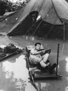 A soldier reads an Armed Services Edition in monsoon conditions during World War II. Australian War Memorial/Courtesy of Houghton Mifflin Harcourt