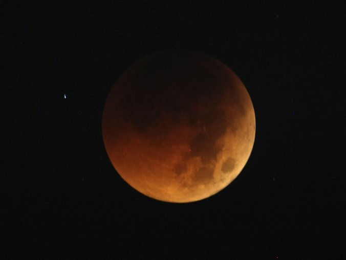 The moon exhibits a deep orange glow as the Earth casts its shadow in a total lunar eclipse as seen in Manila, Philippines, before dawn Thursday in a June 2011 eclipse. Bullit Marquez/AP