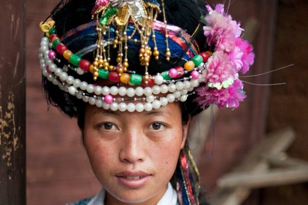 La Chuo Zhu Ma, 27, in traditional dress before a fire dance in Xiaoluoshui, a village on the edge of Lugu Lake. Each night, around 400 tourists are charged 30 CNY (around $5) to attend these spectacles. Profits are evenly distributed throughout the surrounding villages. (Dave Tacon)