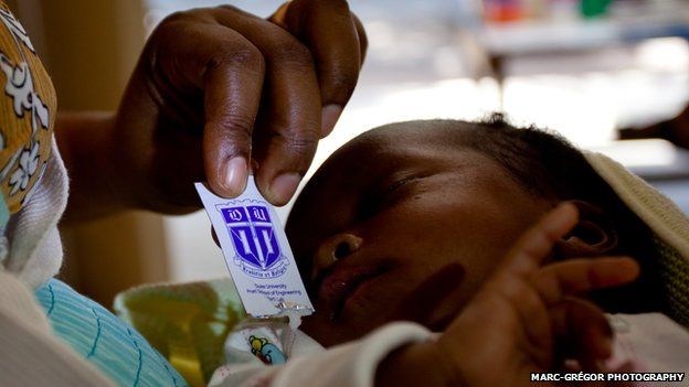 An HIV positive mother in Moshi, Tanzania, giving her baby antiretroviral medicine from the sachet