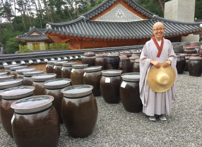 Sun Woo directs the visitor program at Jinkwansa, a Buddhist temple outside Seoul famous for preserving the art of Korean temple food. Behind her are giant jars filled with fermented soybeans. PHOTO: Ari Shapiro/NPR