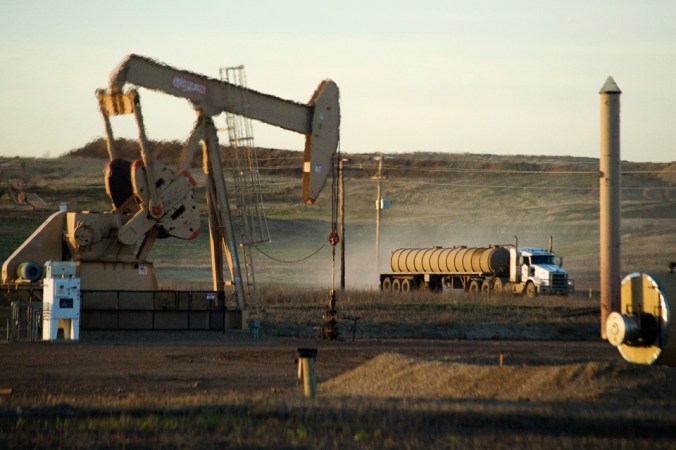 A service truck drives past an oil well on the Fort Berthold Indian Reservation in North Dakota, which produces nearly a third of US' oil. PHOTO: Andrew Cullen