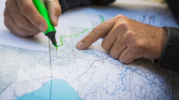 Plum Creek forester Steve Griswold examines a map of the Checkerboard forest.